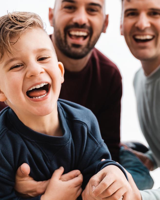 smiling boy with two smiling men