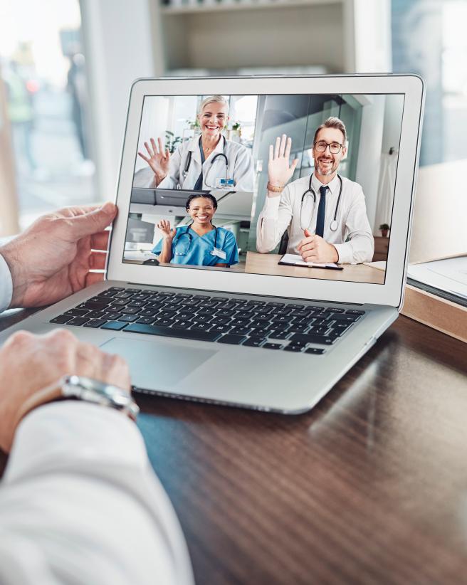 Person videoconferencing with three doctors on laptop