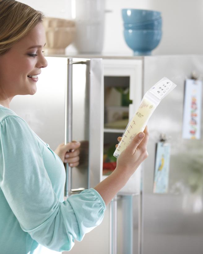 woman putting bag of breastmilk in freezer