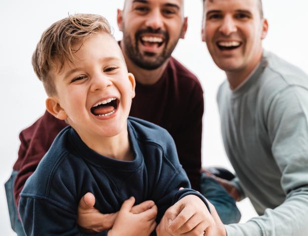 smiling boy with two smiling men