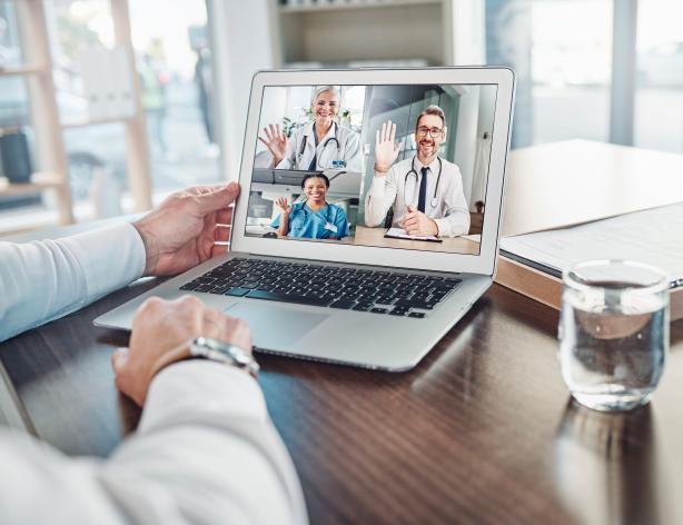 Person videoconferencing with three doctors on laptop