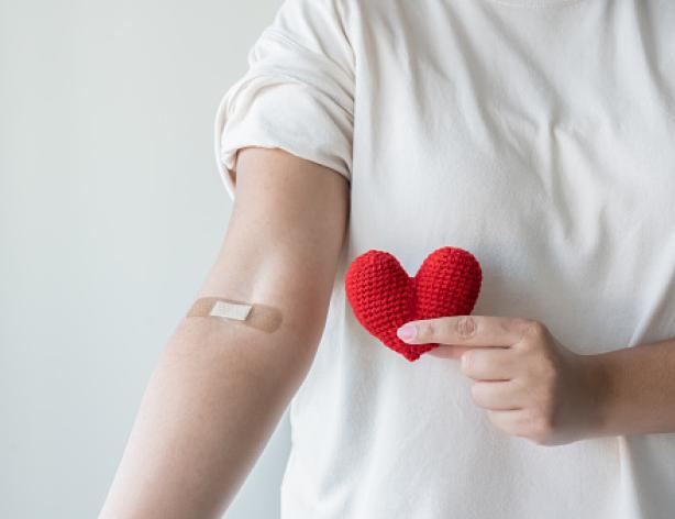 Person with bandage on inside of elbow after blood test